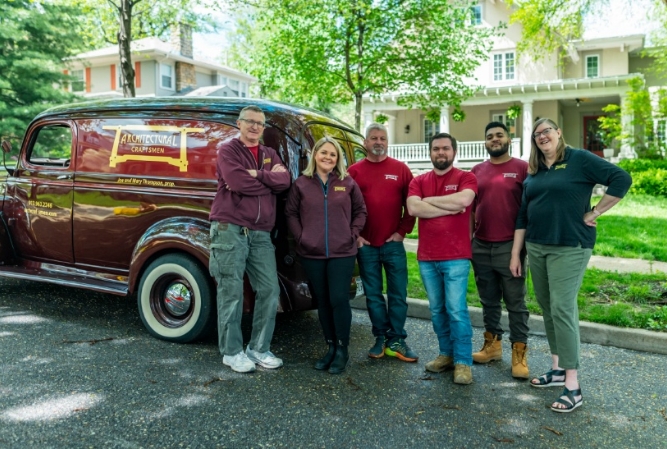 the architectural craftsmen team posed in front of their panel van and a historic home