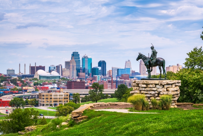 a view overlooking kansas city from the west, with a bronze horseman statue in the foreground