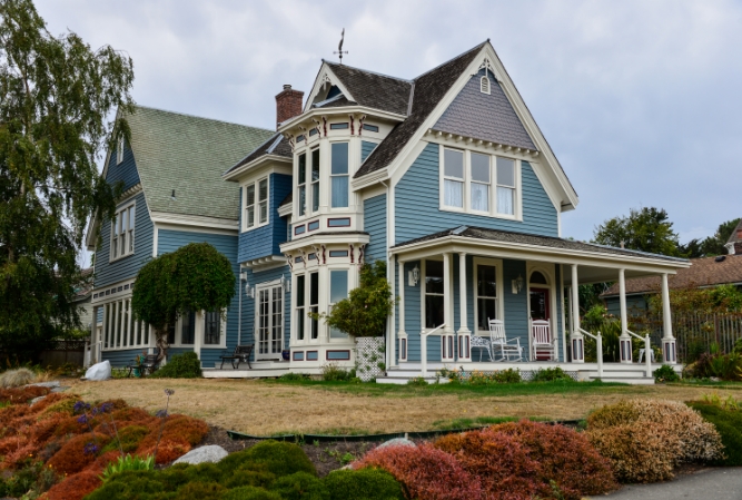 a two-story victorian home with baby blue siding and white wood trim