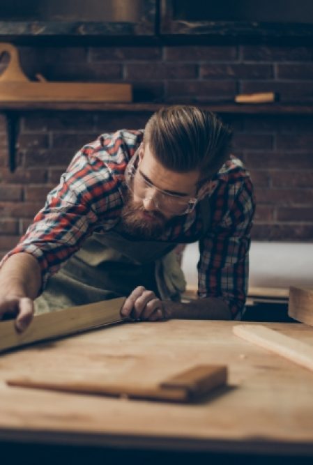 a man works with boards on a woodworking table